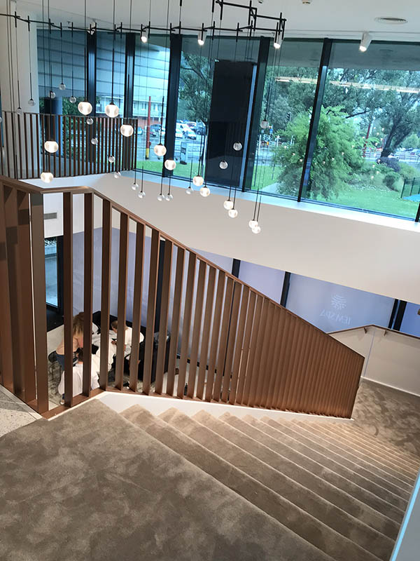 Hotové interiérové schodisko so zábradlím vo farbe medenej patiny pri pohľade na schodisko zhora | DOMO GLASS