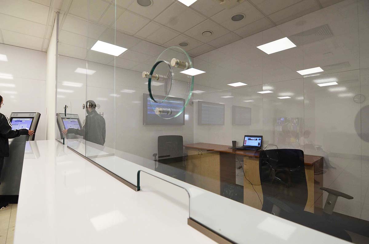 Ochranná bariéra na pult informačnej kancelárie so zvukovodom a spodnou priehradkou ako sklenená zástena na mieru| DOMO GLASS