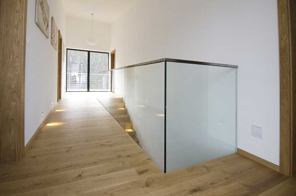 Vrchný pohľad na ukončenie skleneného zábradlia na poschodí s nerezovým vrchným madlom | DOMO GLASS